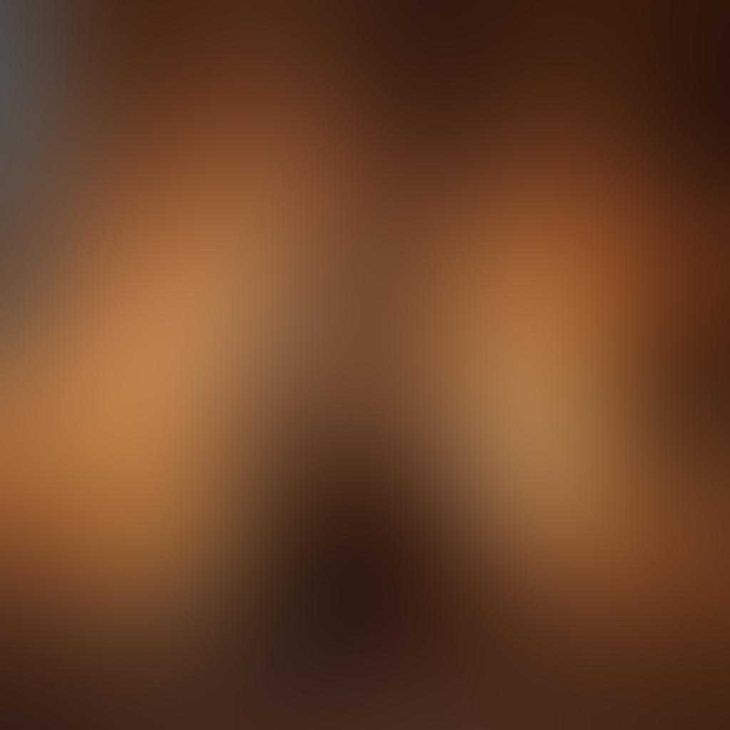 An intimate scene illustrating the transition from affection to passion, with a couple sharing a tender embrace in a cozy, dimly lit room. Surround them with hints of romance like heart-shaped candles and soft pillows, while softly blurring adult film posters in the background. Capture a warm color palette to evoke emotion and connection, blending elements of romance and desire creatively. super-realistic. warm tones. cozy atmosphere.